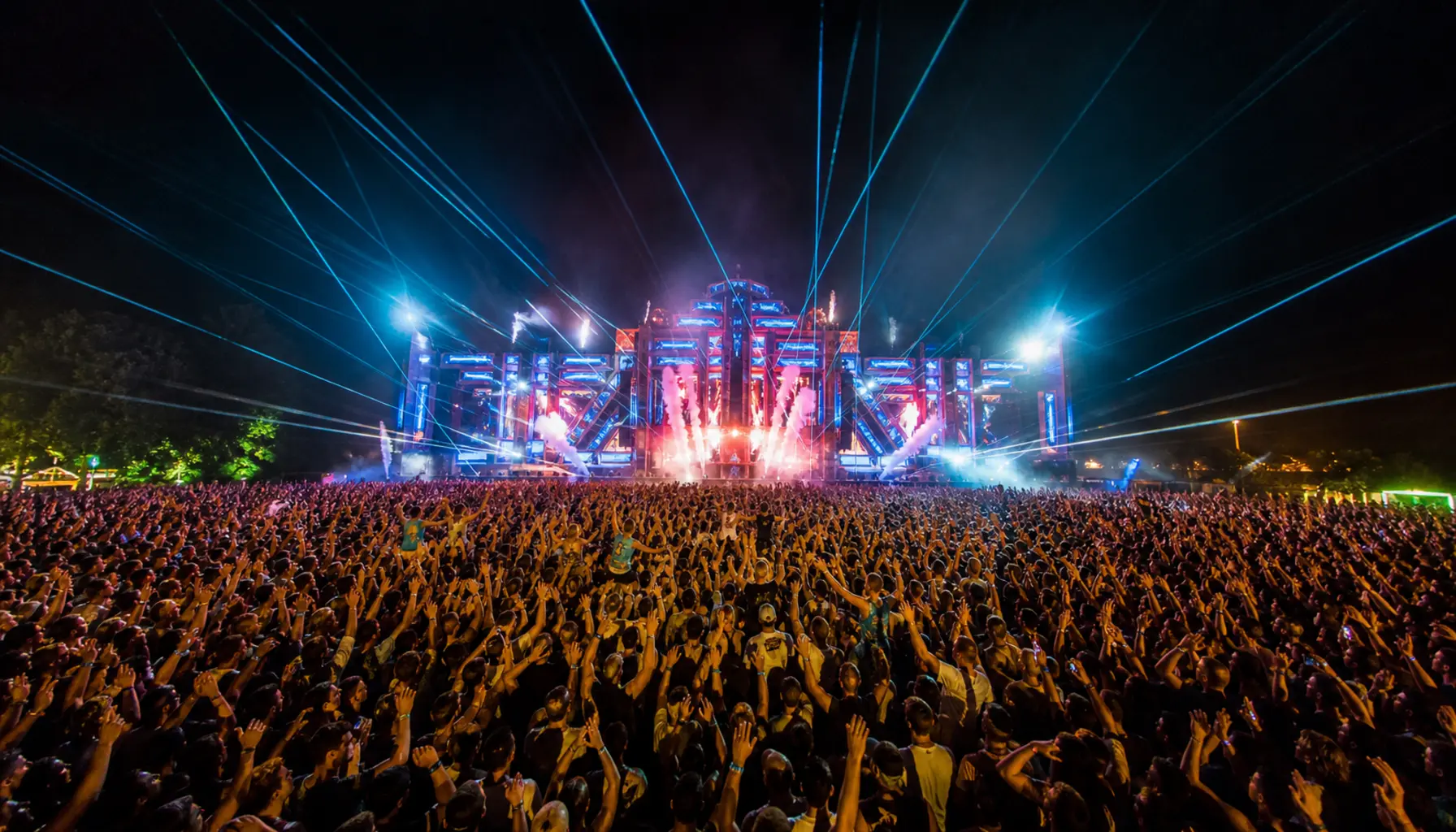 Crowd and stage lights at an open-air music festival at night