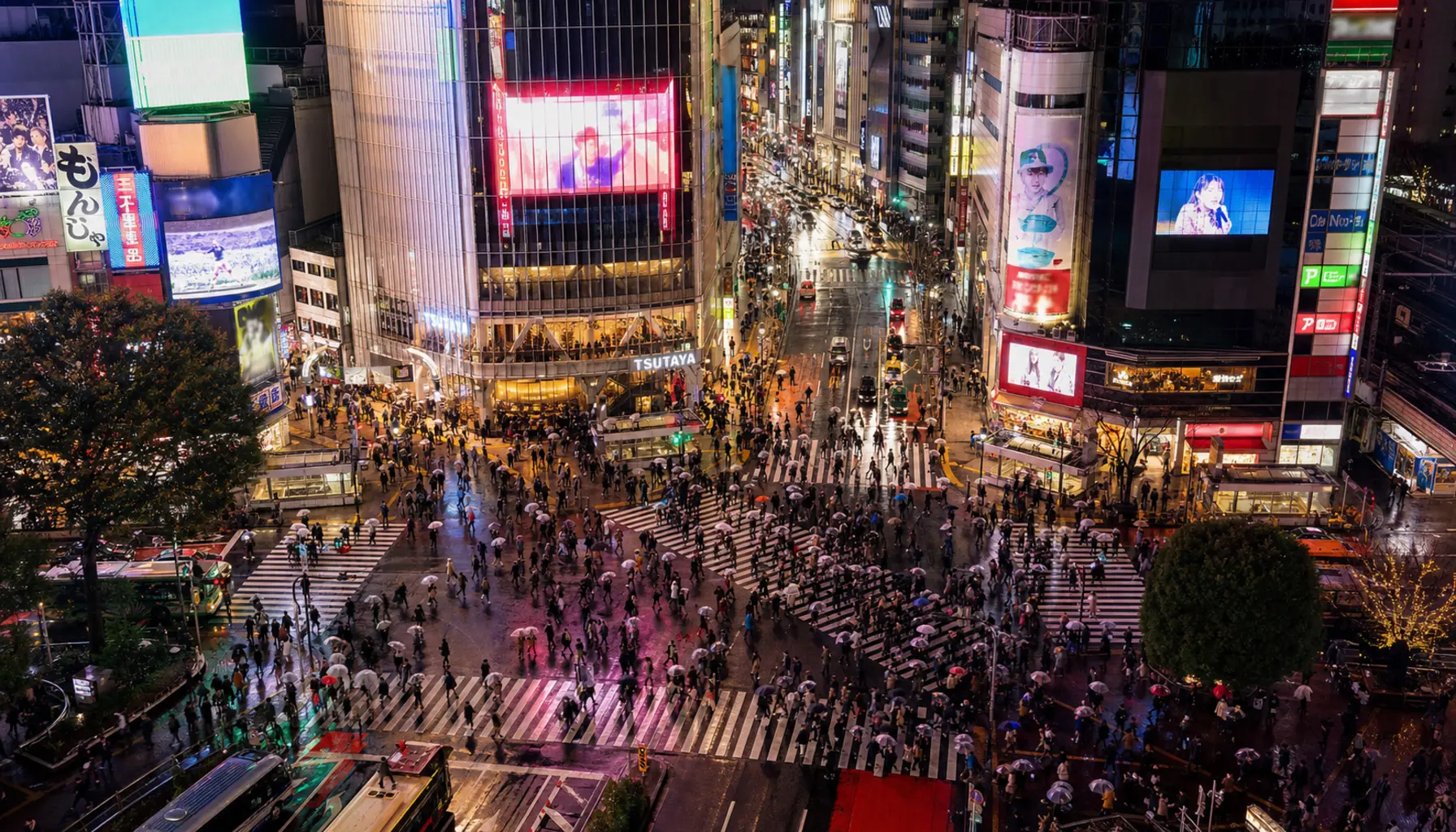 Neon signage reflected on wet streets in Shibuya, Tokyo