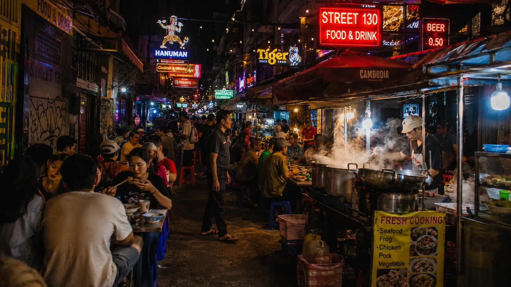 Phnom Penh Street 130 food strip at night with neon signs for Angkor Beer and Tiger, outdoor diners under tarps and \