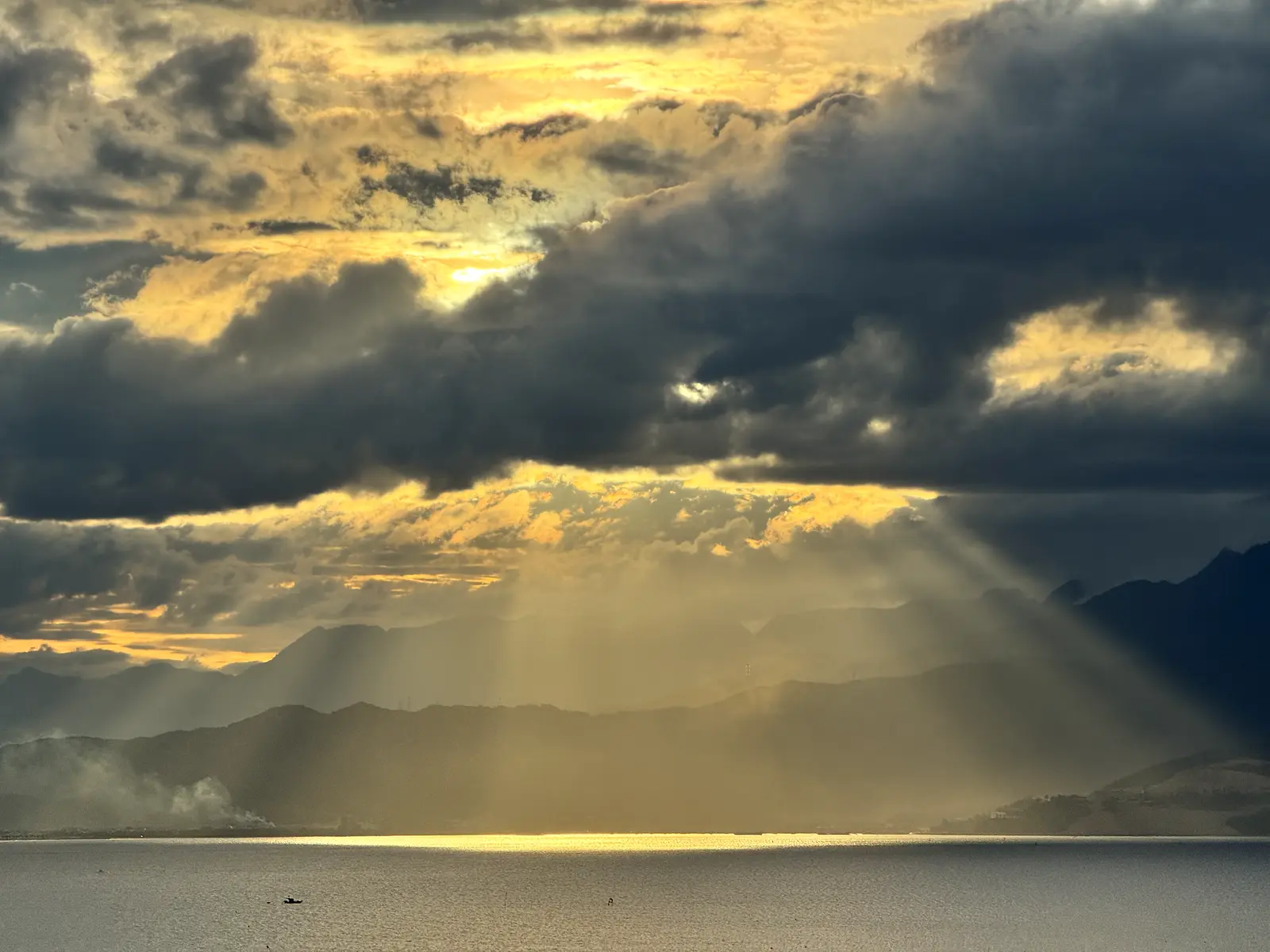 Crepuscular rays breaking through storm cloud over Da Nang Bay